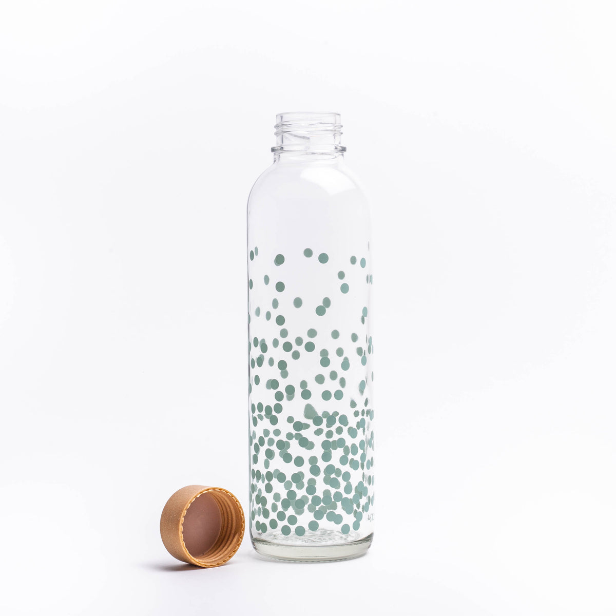 Glastrinkflasche mit blauen Punkten neben Deckel